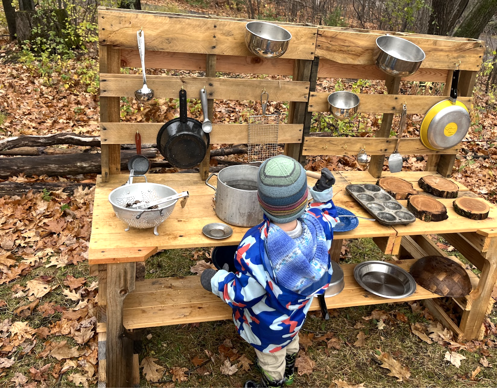Child playing at an outdoor mud kitchen